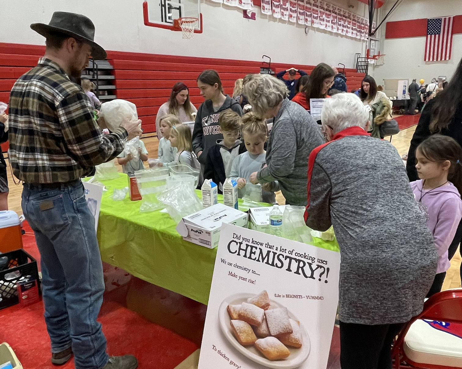Students and their families take part in a hands-on chemistry experiment provided  by the Beans & Beignets restaurant, among other STEM exhibits, at the ﻿Earlham Family STEM Festival.